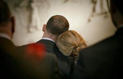 a man and a woman with backs turned. Woman's head rests into man's neck
