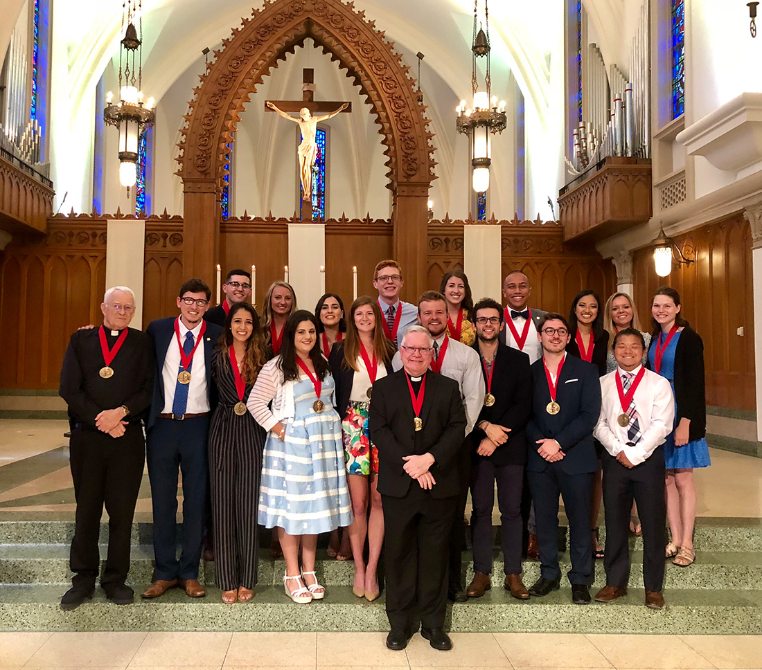 Winners of the 2018 St. Ignatius of Loyola Medal standing together at the front interior of Sacred Heart Chapel