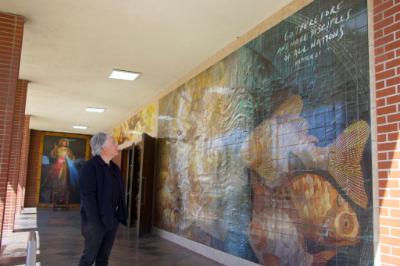José García Moreno looks over the new tile mural he created at Holy Family Church in Artesia, which has a “fishers of men” theme.