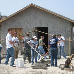 student workers standing in front of a structure they built with tools