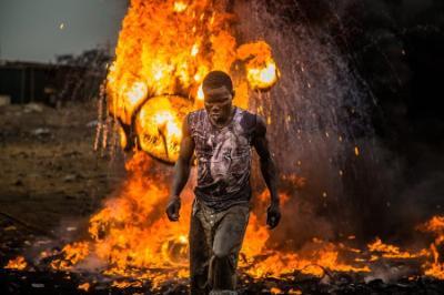 Scene from Welcome to Sodom movie; man walking amidst fire