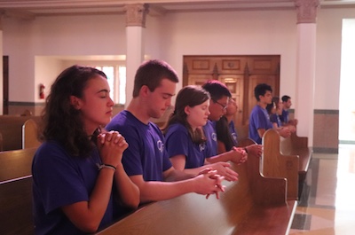 Students praying in pews of Sacred Heart Chapel