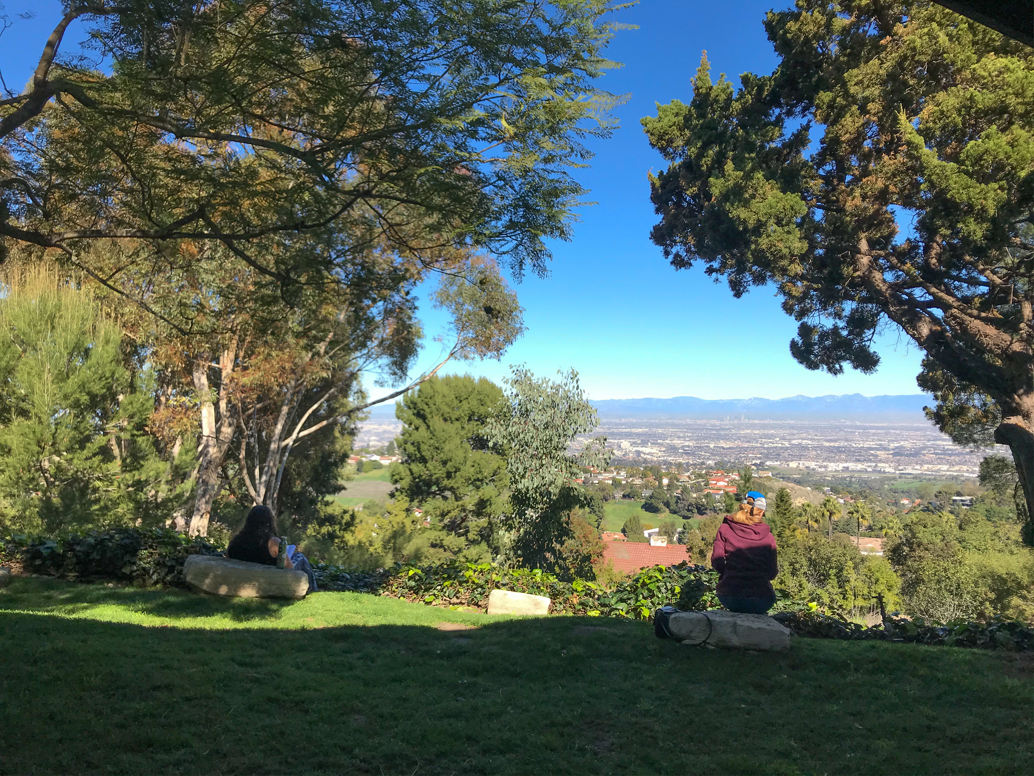 Two people sitting overlooking a view of Los Angeles