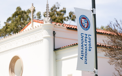 Top of Sacred Heart Chapel with LMU brand banner nearby