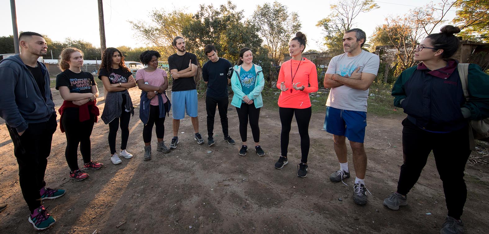 A group of students standing outside talking in a semi circle